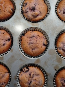 A photograph of nine Sour Cherry Muffins sitting in a muffin tin.  